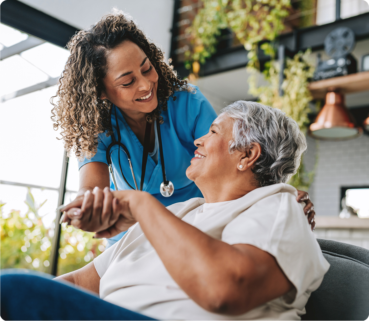 Nurse comforting elderly patient at home
